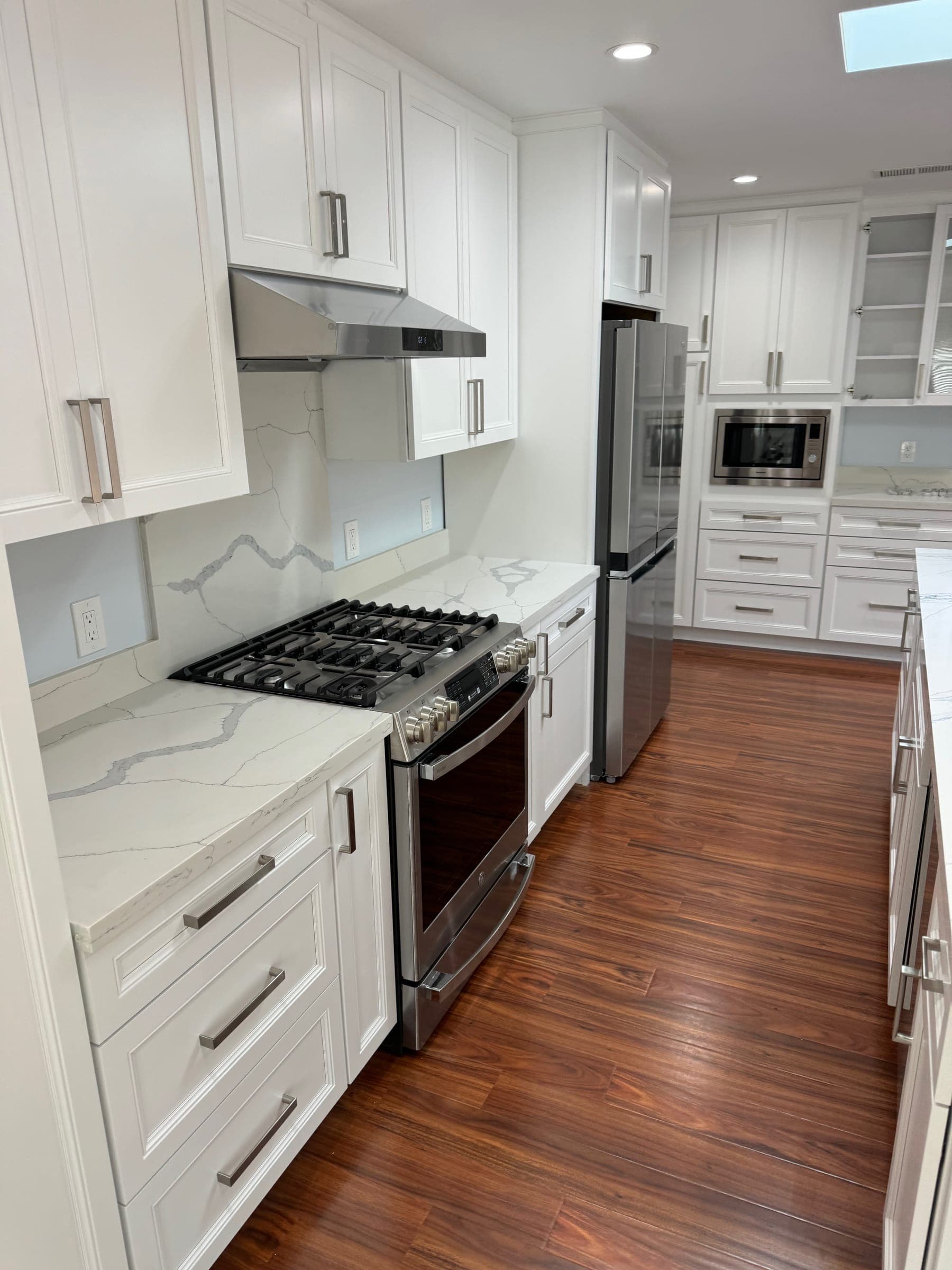 Remodeled open-concept kitchen with quartz counters and stainless appliances